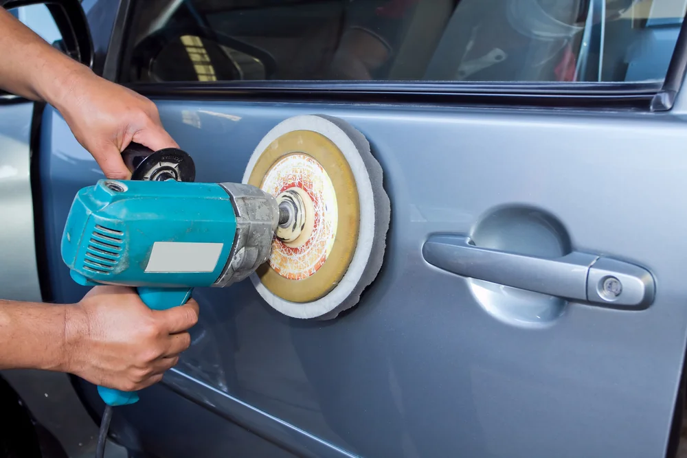 Panel beater polishing a car door panel after smash repair — TKM Smash Repairs, Edmonton QLD