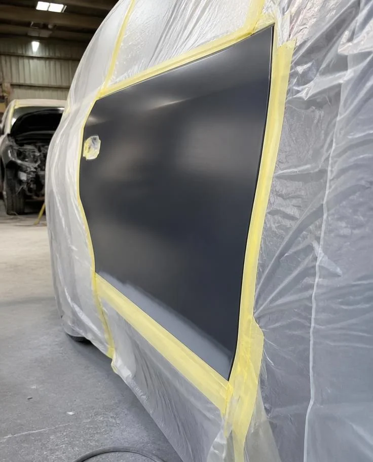 Car door masked with tape and plastic sheeting ready for spray painting — TKM Smash Repairs, Edmonton QLD